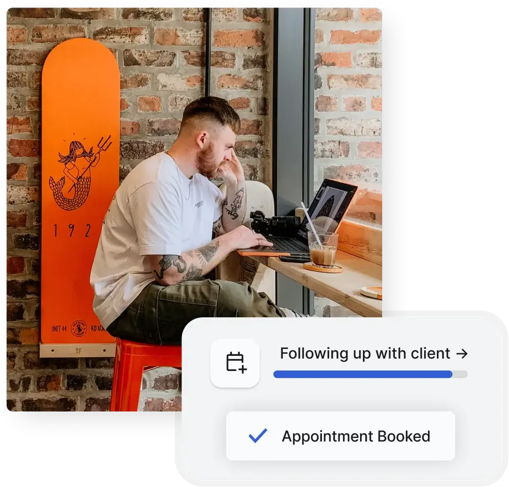 Professional working on a laptop while an AI employee books an appointment